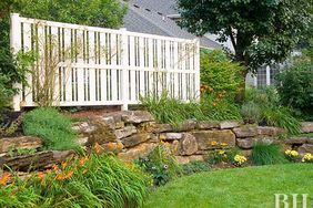 Slope, Backyard, Fence, Stone Wall, Lawn, BHG.com, Better Homes and Gardens