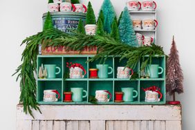 Santa mugs sit stacked on shelves