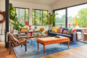 living room with blue rug and orange bench