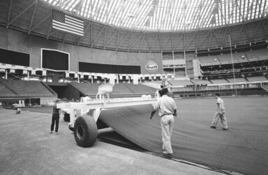 Workers lay AstroTurf at the Astrodome in Houston, July 13, 1966. Artificial turf has come a long way since since it was introduced on a grand stage to the sports world at the Astrodome.