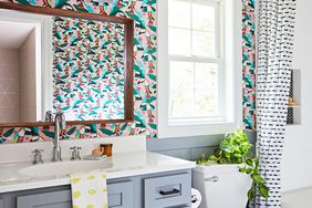 bathroom with pattern wallpaper and blue vanity