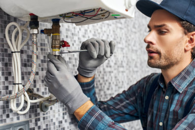 best plumber working beneath a sink with tool