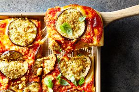 a tasty square pizza with a slice being lifted out