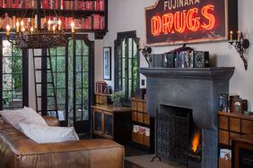 Dark Americana living room with rustic sign, fireplace, brown leather couch