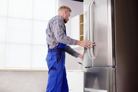 person preparing to move a fridge