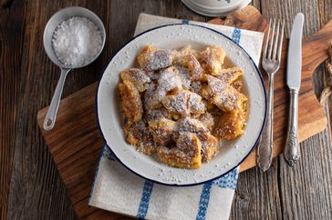 scrambled pancakes on plate on wooden cutting board