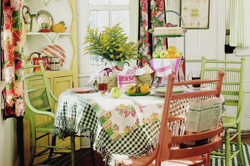 white kitchen with gingham tablecloth and green chairs