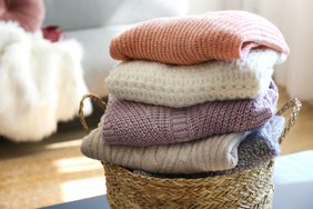 stack of wool sweaters in laundry basket