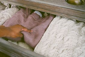 hand putting sweater in drawer