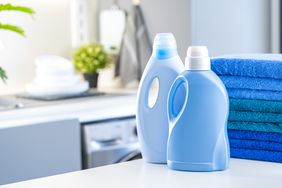 blue liquid laundry detergent bottles in laundry room setting