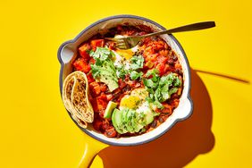 a skillet filled with assorted veggies and a tortilla wrap