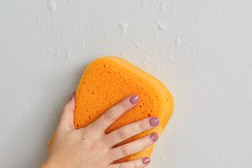 scrubbing wall with orange sponge