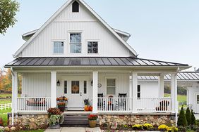 white board-and-batten country house with walkway pavers