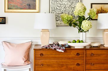 wooden dresser with flowers and pink lamps